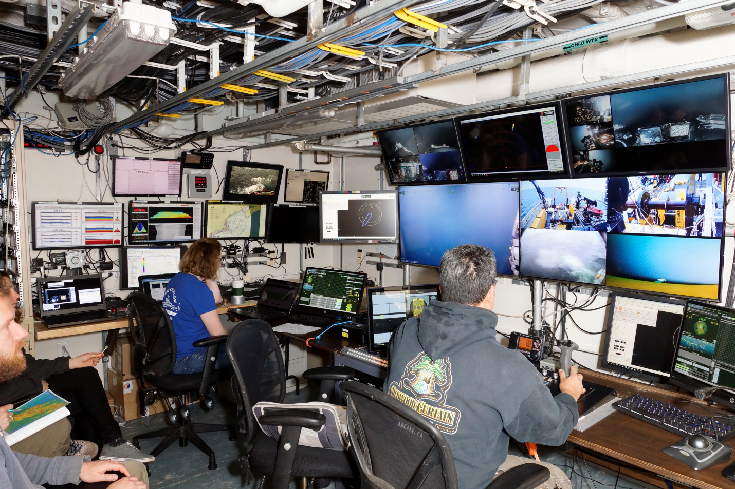 ROV pilots monitoring sonar and live subsea video in a control room